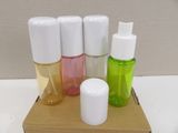 four bottles of different colors and sizes on a cardboard box