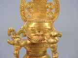 a gold figurine of a man with a crown on his head
