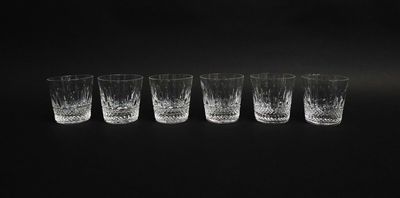 quatre verres à shot sont alignés sur un fond noir