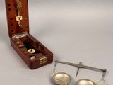 a wooden case with a pair of bells and a pair of measuring spoons