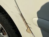 a white car with a hole in the side of it