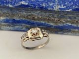 une bague en or blanc avec un diamant serti au centre