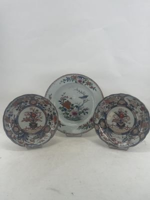 three plates and a bowl are sitting on a white surface