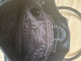 black leather handbag with logo on the inside of it