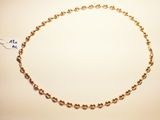 a close up of a gold chain with a tag on it