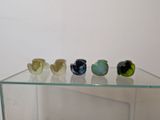 a glass display case with five glass birds on it