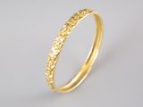 gros plan d'une bague en or sur fond blanc
