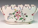 a white bowl with flowers on it sitting on a table