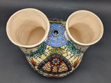 a vase that has two cups in it on a table