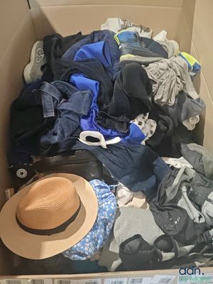 une boîte remplie de vêtements, avec un chapeau à l'intérieur