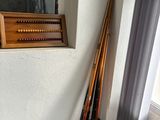 some baseball bats are leaning against a wall near a window