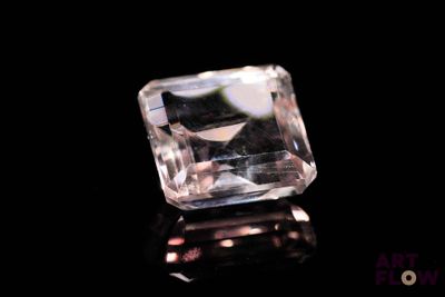 a close up of a clear crystal stone on a black surface