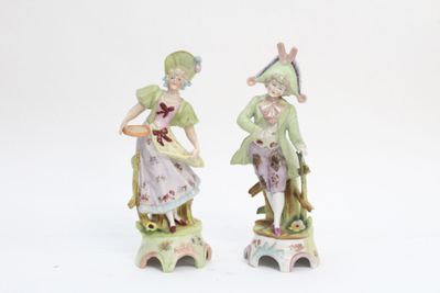 deux figurines représentant un homme et une femme assis sur un tabouret