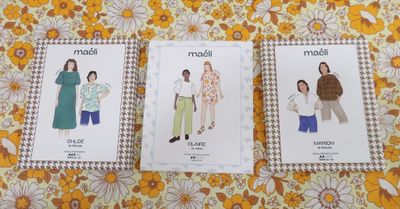three sewing patterns of women ' s clothing on a yellow floral background
