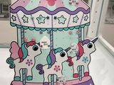 a paper cutout of a carousel with unicorns on it