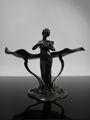 a black and white photo of a statue of a woman holding a flower