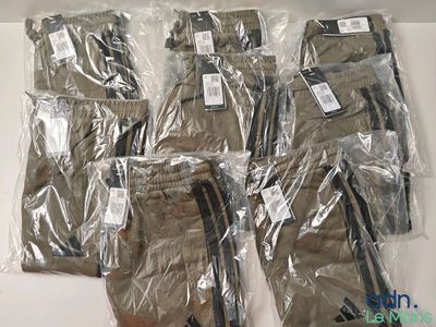 six paires de pantalons pour homme emballées dans du plastique, posées sur une table