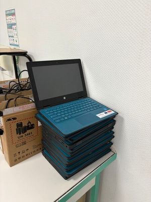 une pile d'ordinateurs portables empilés les uns sur les autres sur une table