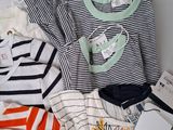 a lot of baby clothes that are laying on a bed