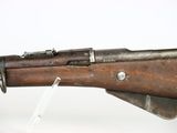 an old rifle with a wooden barrel on a white surface