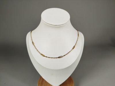 un gros plan d'un collier porté par un mannequin posé sur un présentoir