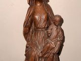 statue en bois représentant une femme tenant un enfant dans ses bras, posée sur une table