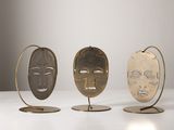 trois masques métalliques posés les uns sur les autres sur une table