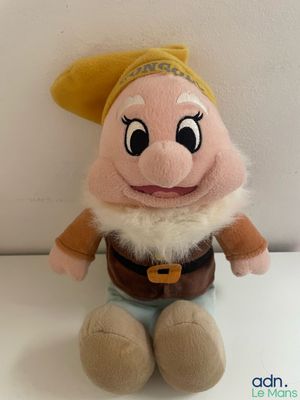 disney snow white and the seven dwarfs plush toy sitting on a white surface