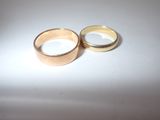 two wedding rings sitting on a white surface