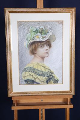 tableau représentant une femme coiffée d'un chapeau, posé sur un chevalet