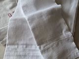several white towels are stacked on top of each other on a table