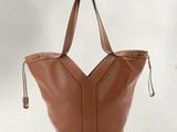 a brown leather tote bag on a white background