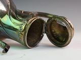 a silver vase with a green glass inside of it