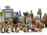 many different bottles of perfume on a white surface