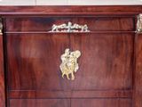 a wooden chest of drawers with a gold decoration on it