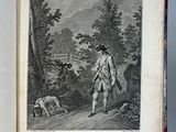 an old book with a drawing of a man walking a dog in the woods