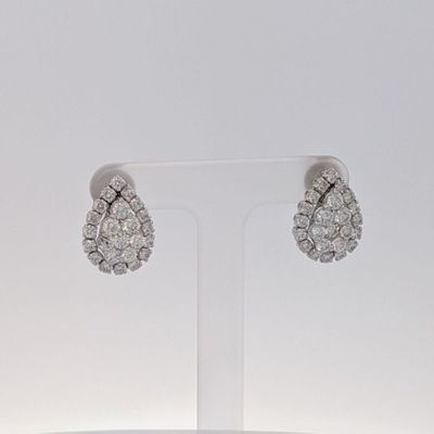 une paire de boucles d'oreilles en or blanc et diamants exposée sur un présentoir