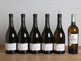 six bouteilles de vin sont alignées sur une table en bois