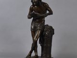 a bronze statue of a man with a basket of grapes