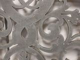 a close up of a decorative metal object on a white surface