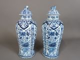 une paire de vases bleus et blancs avec couvercles, sur fond gris