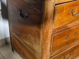 a wooden chest of drawers with a marble top