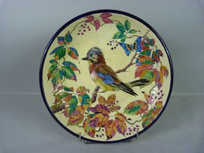 une assiette décorative ornée d'un oiseau, posée sur une table