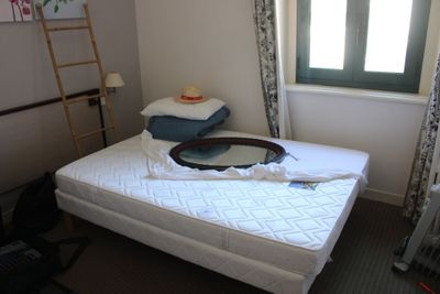 un lit sur lequel est posé un miroir, dans une chambre