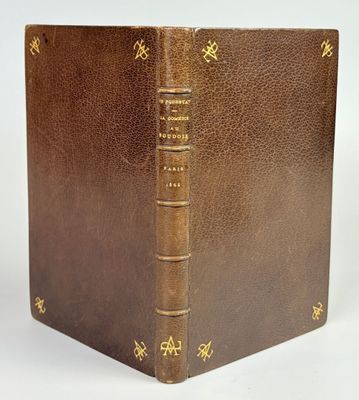 un vieux livre marron aux bords dorés et à la reliure dorée