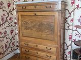 a dresser in the corner of a room with a lamp on it