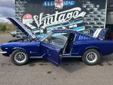une photo d'une Mustang bleue garée devant un magasin
