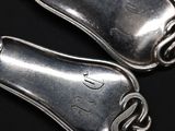 two silver spoons that are sitting on a table