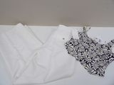 un haut noir et blanc et un pantalon blanc posés sur une table blanche