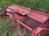 un tracteur rouge assis dans l'herbe